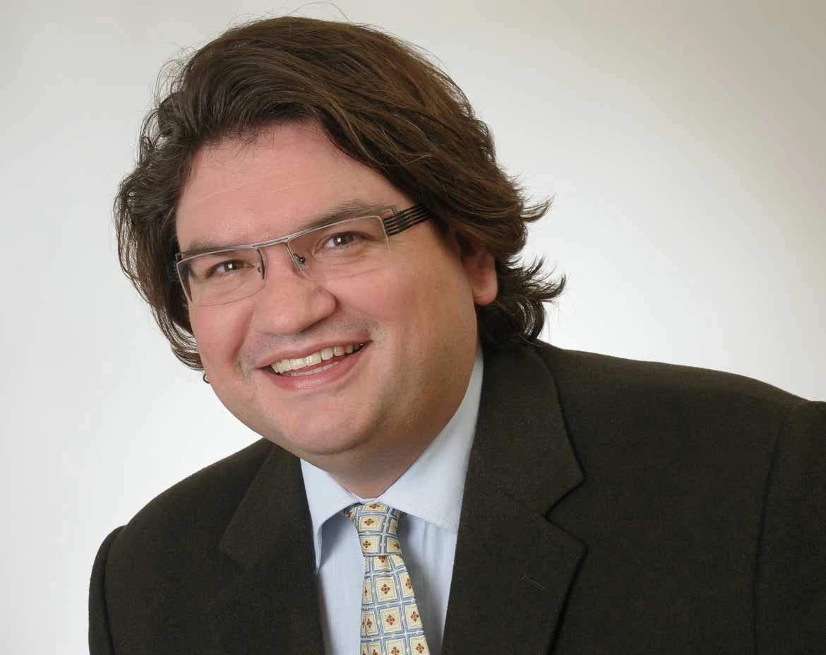 Zahnarzt Dr. Jan Ploke, Inhaber der Zahnarztpraxis, im Anzug, lächelnd